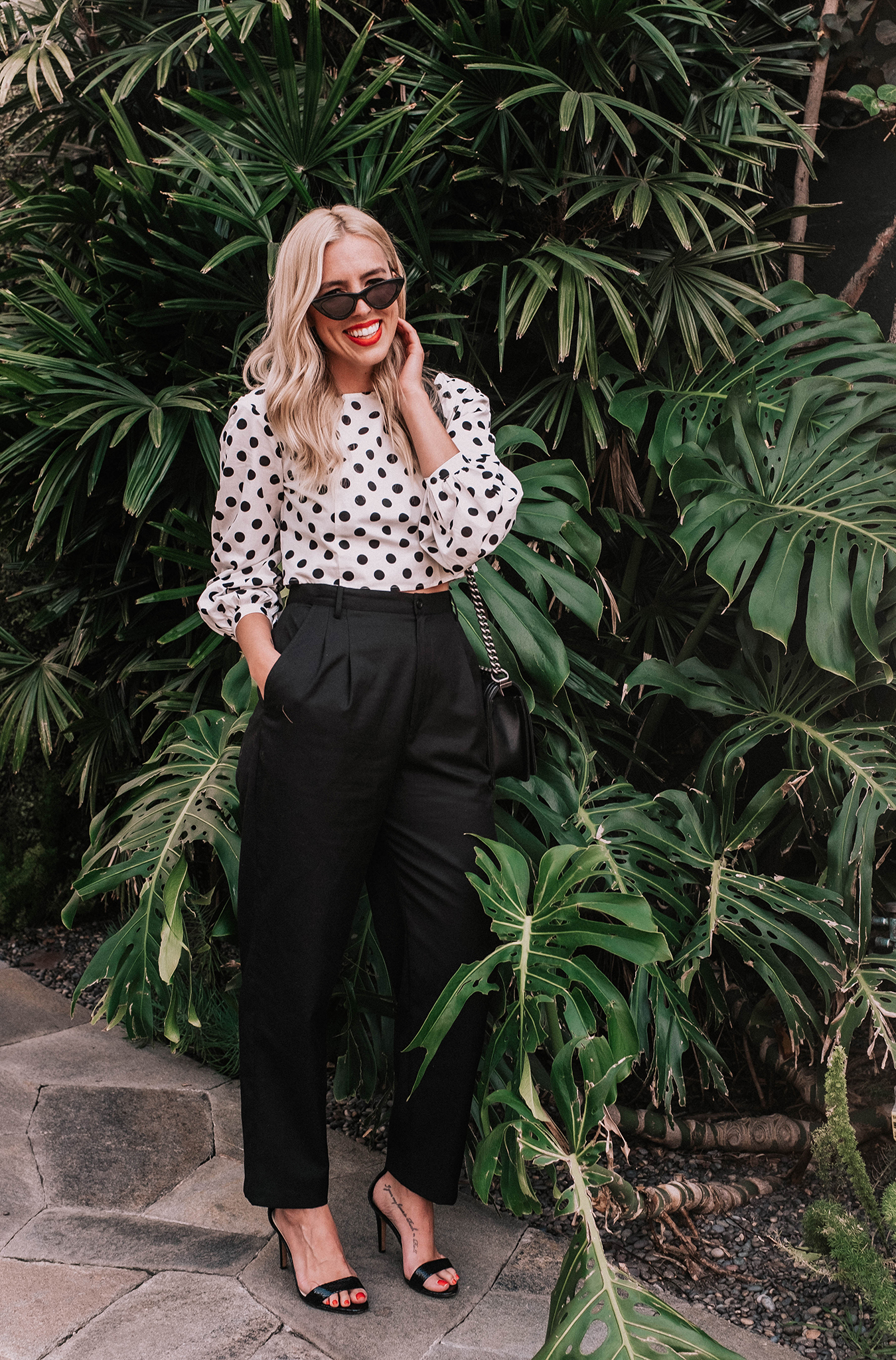 woman wearing polka dot top with puff sleeves and black pants