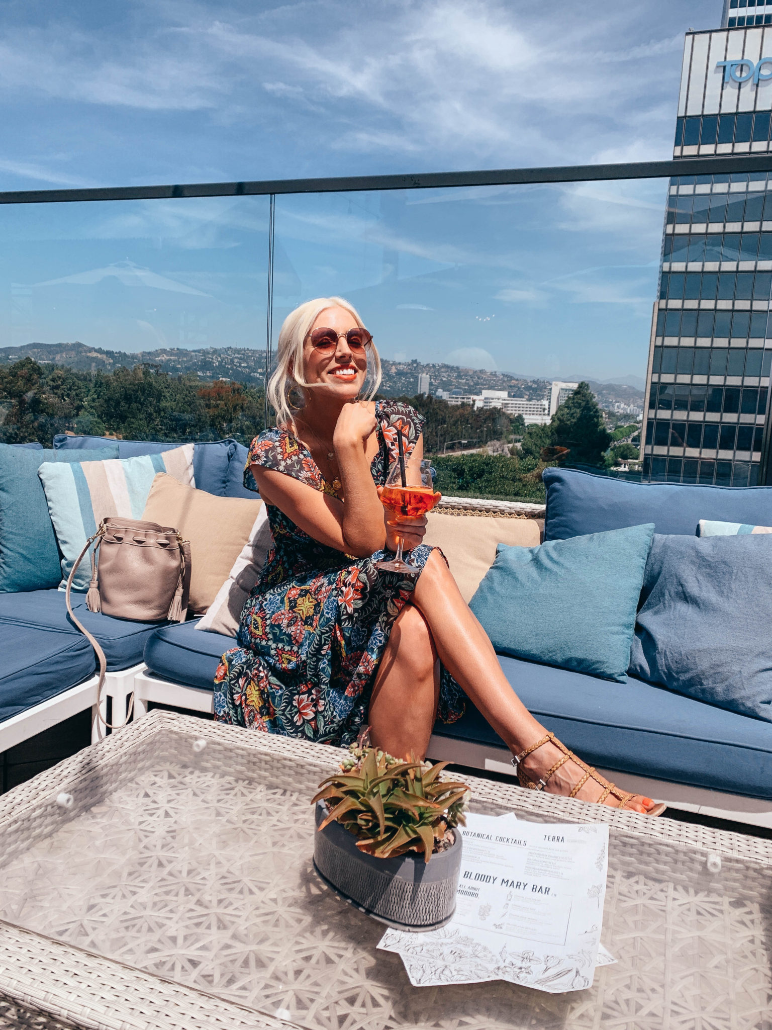woman wearing a dress and holding drink at the best patios and rooftops in LA